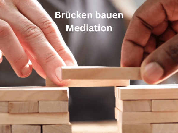 Zwei unterschiedliche Hände bauen gemeinsam eine Brücke aus Bausteinen – ein starkes Symbol für Zusammenarbeit, Verständigung und konstruktive Konfliktlösung.